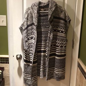 Long sleeveless sweater/coat with hoodie.